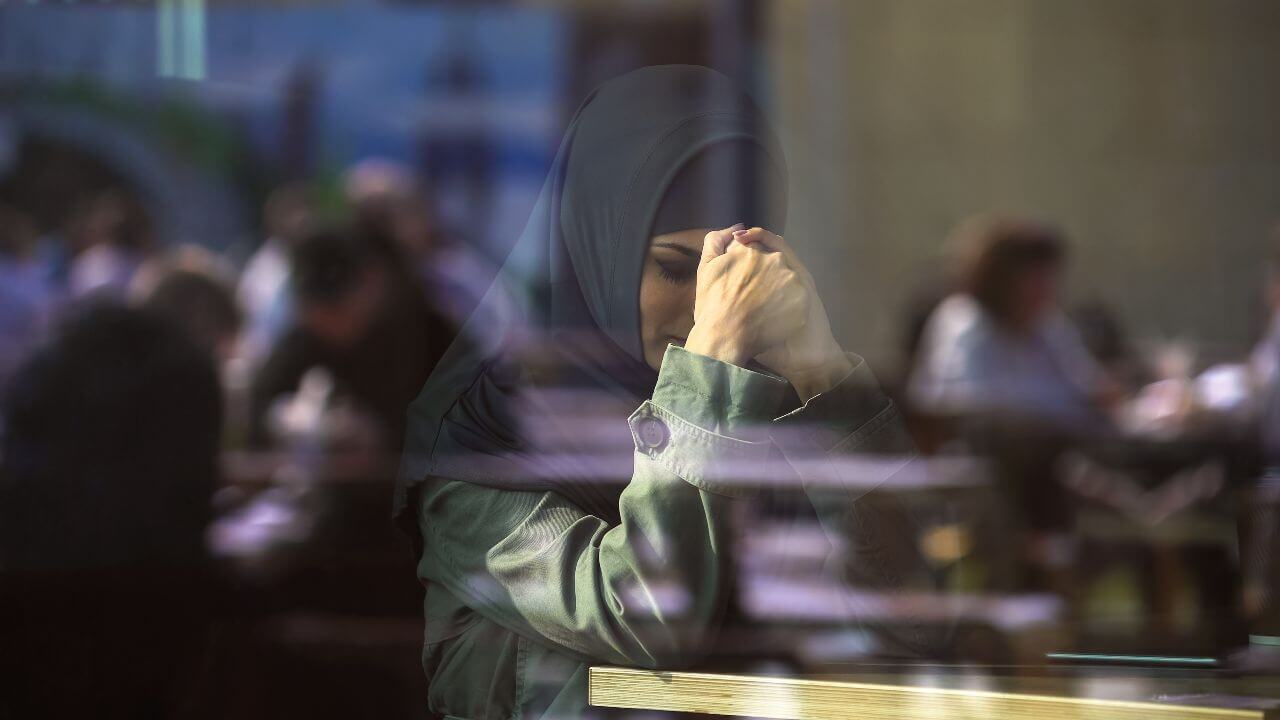 Sad Muslim female in cafe suffering loneliness, emigration problems, divorce